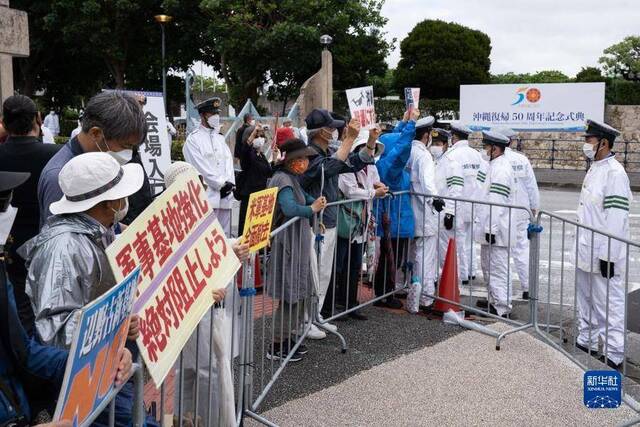 5月15日，人们在冲绳回归日本本土50周年纪念仪式现场外抗议图丨新华社