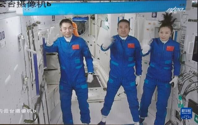 2021年10月16日在北京航天飞行控制中心拍摄的进驻天和核心舱的航天员翟志刚（中）、王亚平（右）、叶光富向全国人民挥手致意的画面。新华社记者田定宇摄