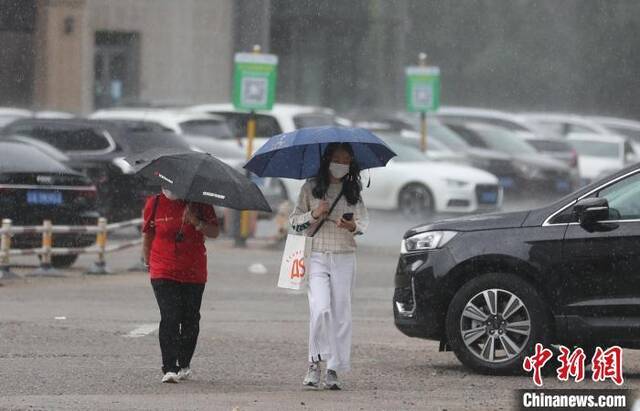 资料图：图为沈阳市民在雨中出行。于海洋摄