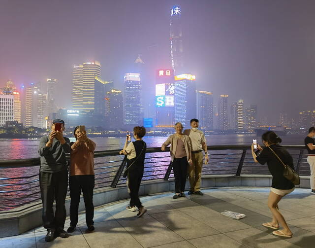 万先生（左一）和老伴在栏杆边拍照。澎湃新闻记者陈少颖图