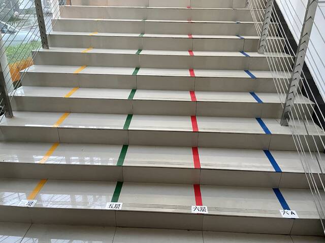 封控区考点楼梯间贴好4种颜色的胶布，为考生和监考老师做好路线指引。丰台区供图（冯玉英摄）