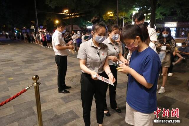 6月6日零时，食客在北京东直门内大街一餐厅外扫码、测温后进入餐厅用餐。中新社记者富田摄