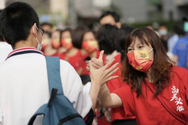 6月7日，在北京市陈经纶中学考点外，送考老师（右）为即将进入考点的考生加油鼓劲。新华社记者鞠焕宗摄