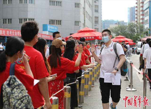 6月7日，北京市朝阳区陈经纶中学高考考点外，送考老师与考生击掌鼓励。当日，2022年全国高考正式拉开大幕。中青报·中青网记者陈剑/摄