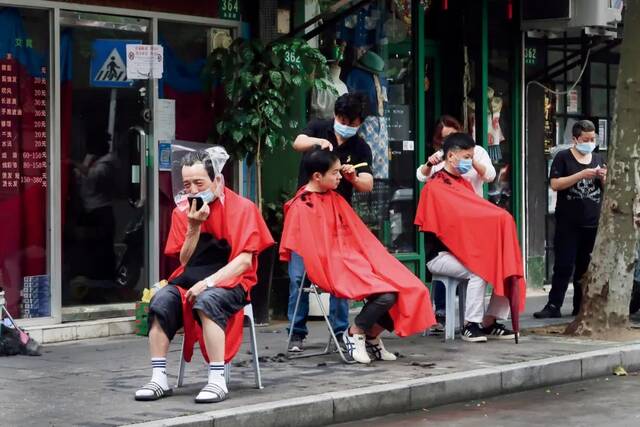 5月29日，理发师在上海街头为人们理发。图/人民视觉
