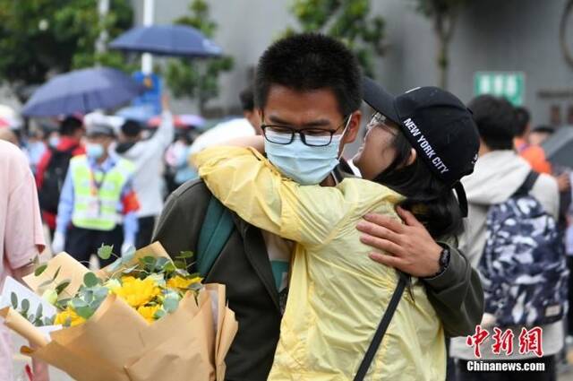 6月8日，一名考生在考点外与家长相拥。当日，云南省2022年高考落幕。中新社记者李嘉娴摄