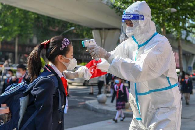 6月10日，在长春市赫行实验学校小学部工作人员为学生测温。新华社记者张楠摄