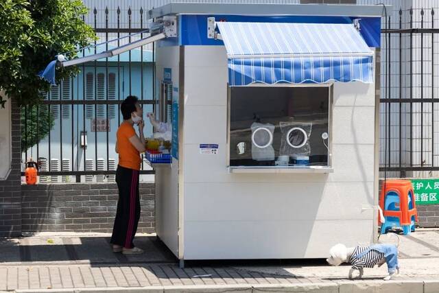 5月31日，在上海市黄浦区福佑路上，市民在核酸采样工作站做采样检测。新华社记者金立旺摄