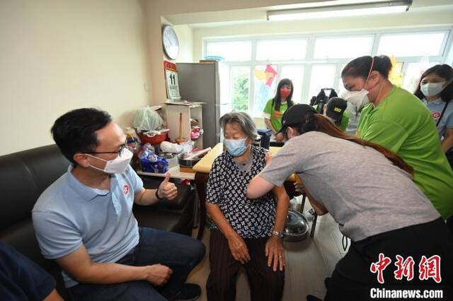 聂德权(左一)鼓励一位居于香港坪洲的80多岁长者(左二)接种第二剂新冠疫苗。香港特区政府新闻处供图