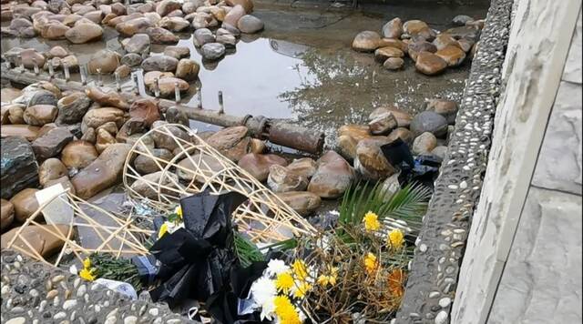 6月12日，店铺对面的水沟里还堆放着残留的花圈。（南方周末记者高伊琛/图）