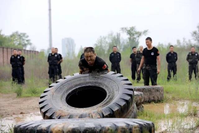 巡特警日常体能训练中，孙建军徒手翻滚400多斤轮胎。受访者供图