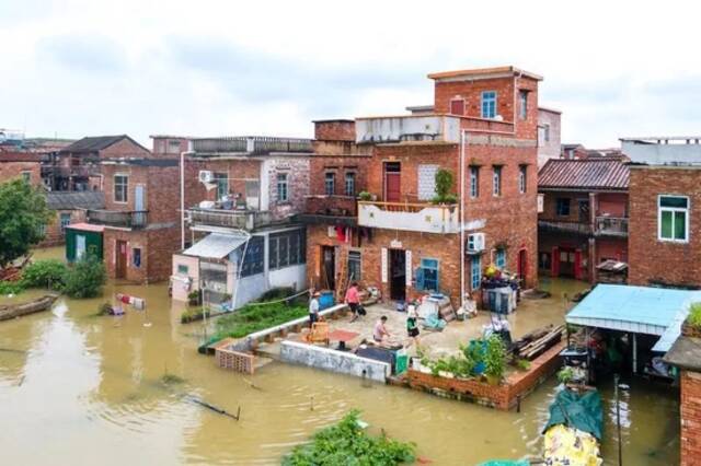 受连日来的暴雨影响，河口社区江边多栋民居一层遭水浸，一些依然留在家中的村民忙着收拾家中的物品。佛山日报记者王澍/摄