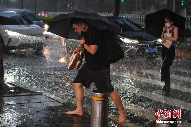 6月15日，广东省广州市，市民在雨中出行。当日，广州受强降雨云团影响，出现强降雨、短时大风天气，多区发布暴雨预警。中新社记者陈骥旻摄