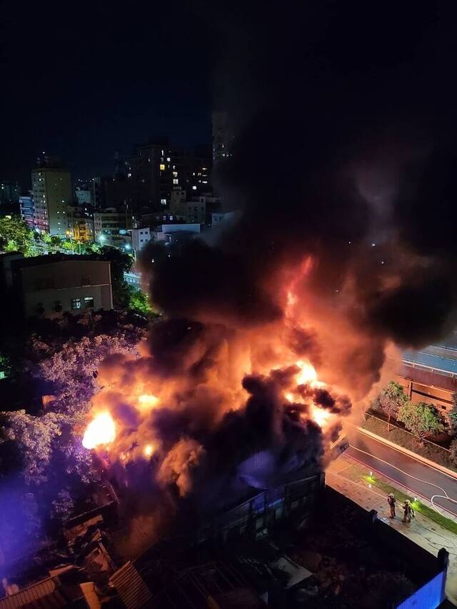 台湾新竹市东大路一段一间轮胎汽车维修厂15日晚间发生火警，消防员获报到场扑灭火势。图片来源：台湾“中央社”