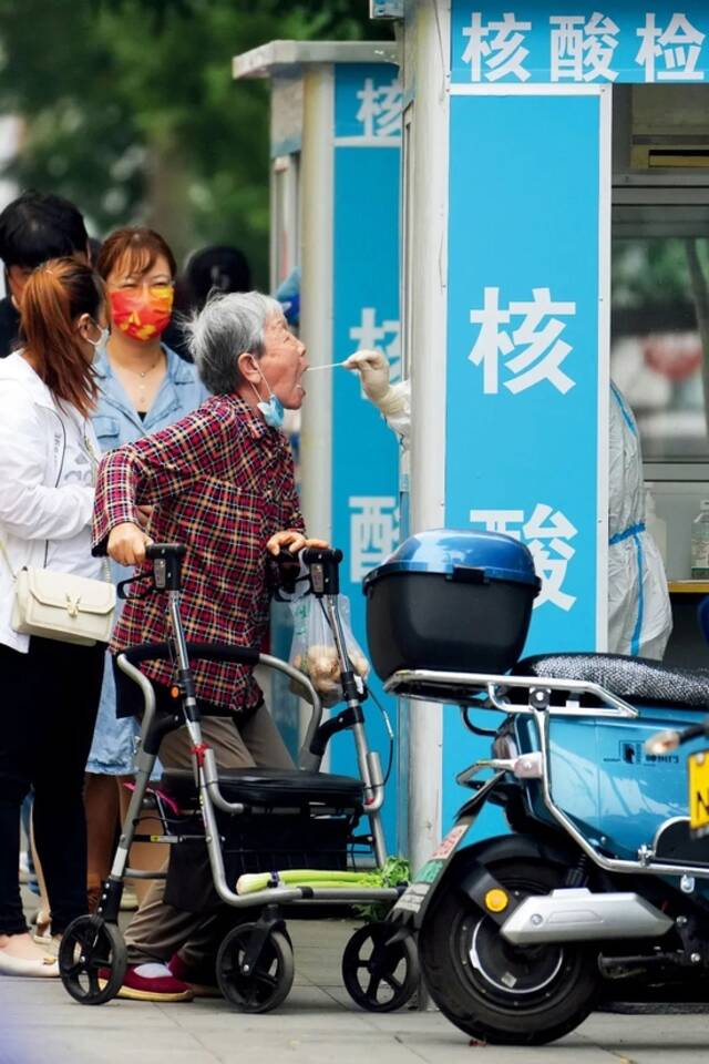 6月11日，在北京市朝阳区八里庄街道一处核酸检测点，居民参加核酸检测。图/新华