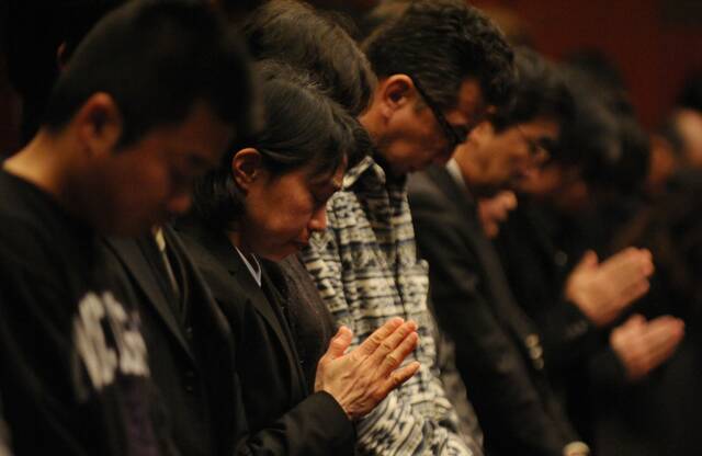 2012年3月11日，在日本福岛县举行的“3·11”大地震一周年追悼仪式上，人们集体默哀。新华社发（关贤一郎摄）