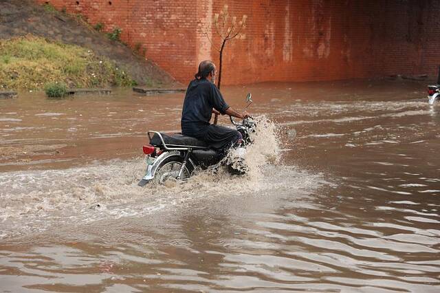 巴基斯坦暴雨引发洪水 民众蹚水过街