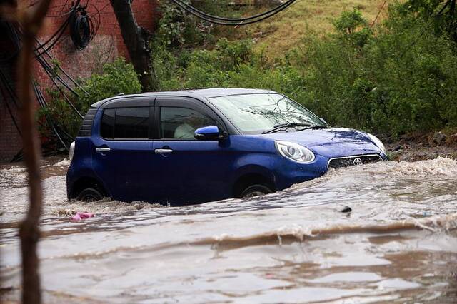 巴基斯坦暴雨引发洪水 民众蹚水过街