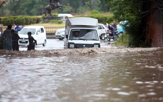 巴基斯坦暴雨引发洪水 民众蹚水过街