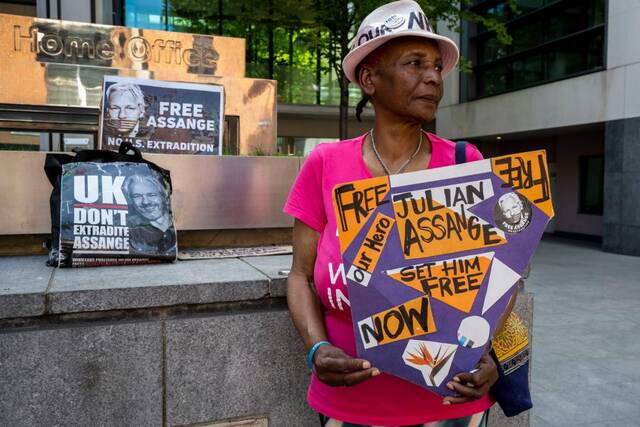 6月17日，示威者在位于伦敦的英国内政部大楼门前手举写有“释放阿桑奇”的标语牌。新华社发（史蒂芬·程摄）