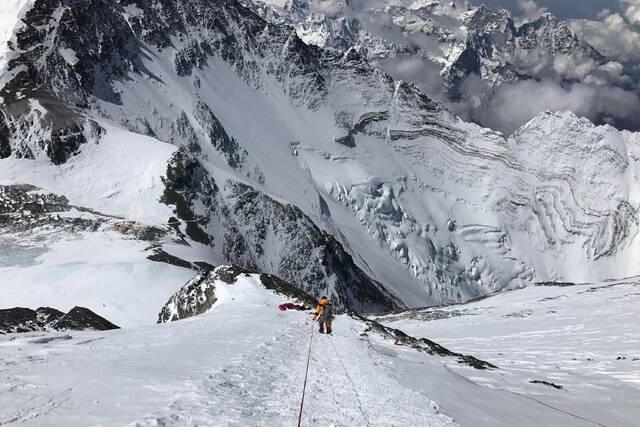 2017年5月21日，登山者凌晨登顶珠峰后，下撤到8200米处，前方是前一夜遇难登山者的遗体。图/IC photo