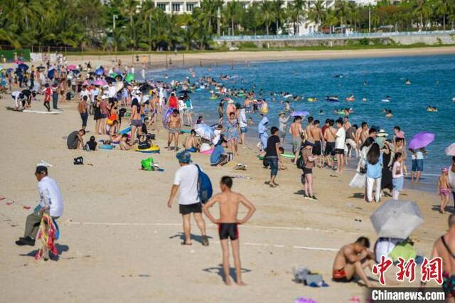 资料图：众多游客在三亚大东海旅游景区海滩享受碧海蓝天。骆云飞摄