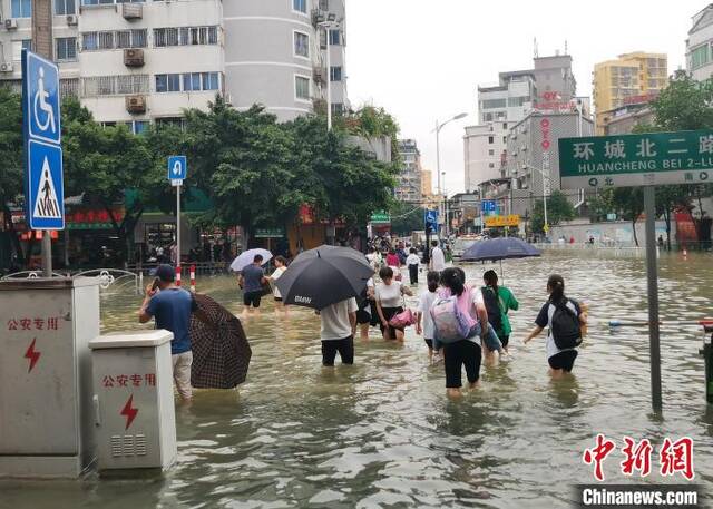 图为桂林市区多地路段积水严重，民众涉水前行。欧惠兰摄