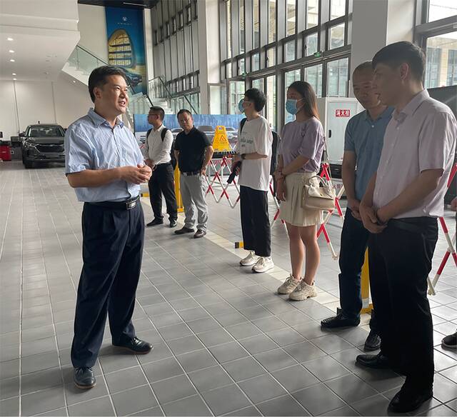 ▲技能大师刘源带领来宾们参观汽车技术实训中心