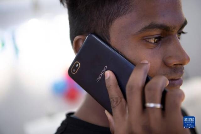2019年10月8日，一名男子在印度金奈的一家商场使用中国品牌的手机。新华社记者吕小炜摄