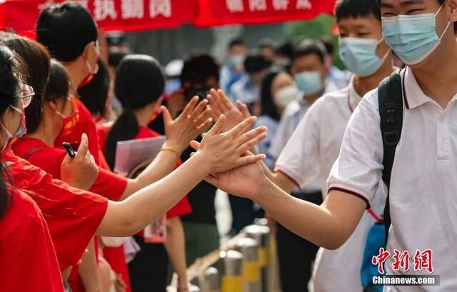 6月7日上午，北京市朝阳区陈经纶中学考点外，参加高考的学生入场前与送考老师击掌。中新社记者侯宇摄