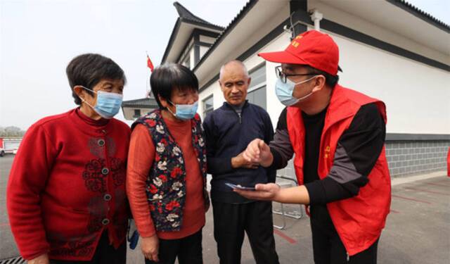 2021年11月4日，江苏省徐州市丰县医保局志愿者向村民讲解医保长期护理保险惠民政策（图|视觉中国）