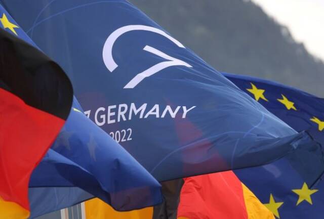 图片说明：24日，德国国旗、欧盟旗和七国峰会旗在德国施洛斯埃尔毛七国峰会新闻中心前飘扬。（德新社）