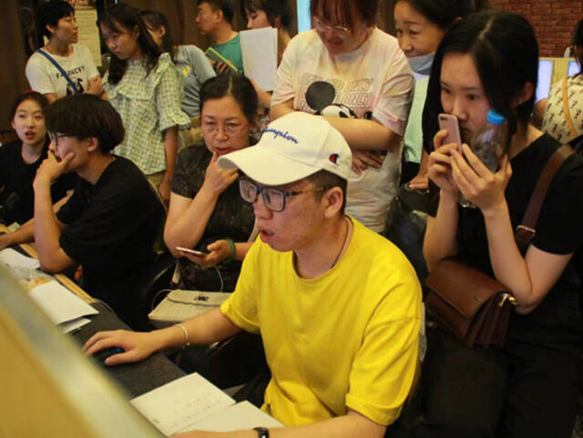 2019年，在内蒙古一间网吧里，家长陪伴着考生填报高考志愿。受访者供图