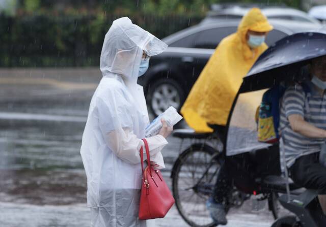7月1日上班早高峰时段，京城又逢降雨天气，人们在各种雨具防护下冒雨出行。
