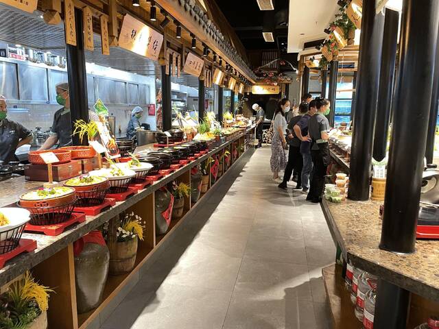 “半亩田”民间菜馆已有序恢复堂食，不少顾客正随着服务员的引导点餐。