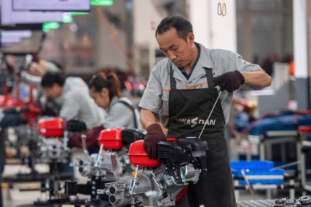 5月30日，在华世丹机械车间内，工人在生产线上组装生产小型农用机械。新华社记者唐奕摄