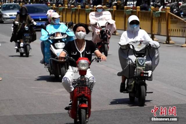 6月17日，陕西咸阳，出行市民包裹严实、遮挡阳光。中新社记者张远摄