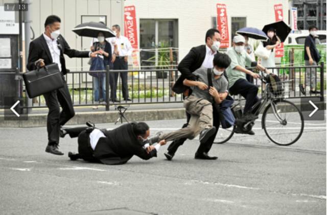 《朝日新闻》发布一张安倍保镖将嫌犯制服时的照片