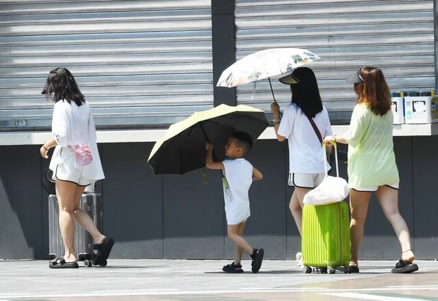 7月8日，重庆街头，市民顶着炎炎烈日出行。图/中新图片网