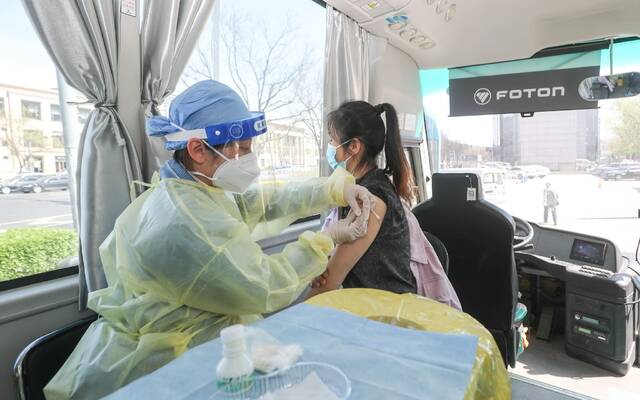 4月14日，北京市天坛街道，市民在流动疫苗接种车上接种新冠疫苗。贾天勇摄/IC photo