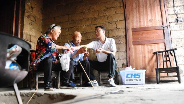 7月5日，彭涛（右一）为村民上门送药时讲解药品的用法用量。新华社记者谢奔摄