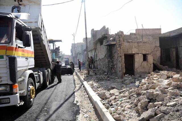 7月4日，工人在伊拉克摩苏尔老城给马路铺沥青。新华社发（哈利勒·达伍德摄）