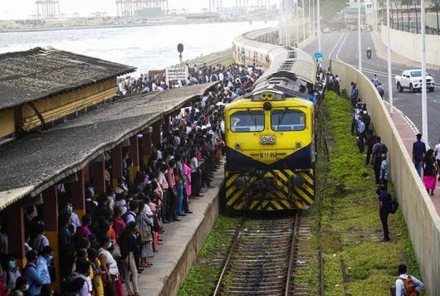 由于燃料短缺和价格提高，加之公共汽车票价上涨，很多斯里兰卡人开始选择火车作为出行工具。图为6月15日，在科伦坡的一处火车站，乘客等待火车进站。新华社
