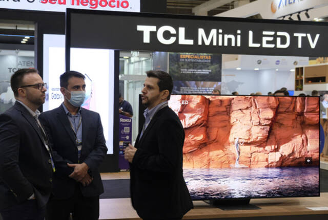 ↑7月11日，人们在巴西圣保罗消费电子展上的TCL公司展台前交流。新华社记者陈昊佺摄