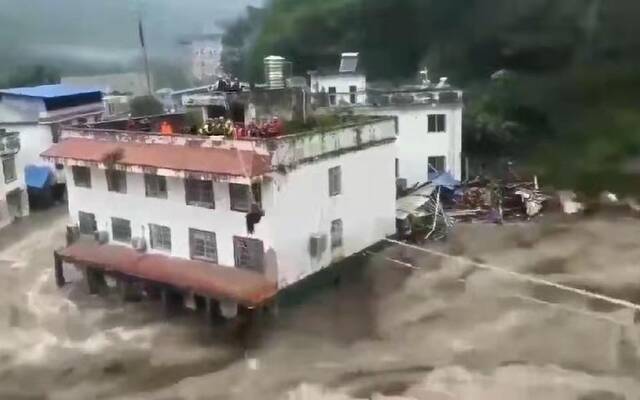 7月12日下午，平武县和平村部分群众被大水困在楼顶。受访者供图