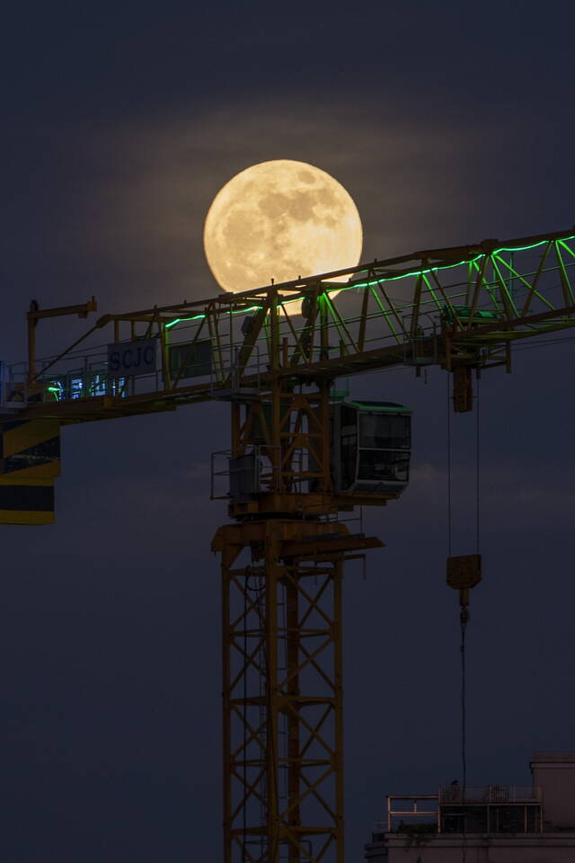 2022年7月13日，一轮明月挂在深圳夜空下的吊车上。