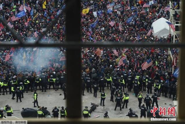 当地时间2021年1月6日，美国参众两院确认选举人团投票结果的联席会议，因现任总统特朗普支持者闯入国会大厦引发大规模骚乱而被迫中断，现场极度混乱。图为美国国会大厦圆形大厅外聚集的特朗普支持者。