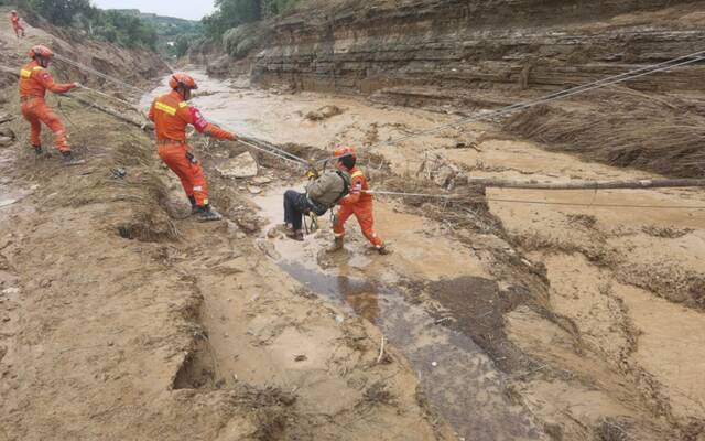 7月16日，甘肃省庆阳市庆城县翟家河乡消防救援人员通过绳索横渡将被困人员转移至安全地带。（甘肃省森林消防总队平凉支队供图）