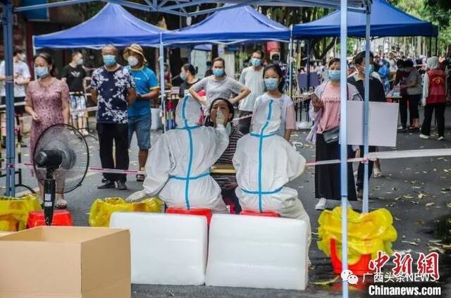 图为核酸采样点，医护人员利用冰块消暑。翟李强摄