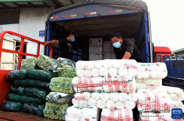 7月18日，在安徽省蚌埠市海吉星农产品批发市场，商户将蔬菜装车准备配送。新华社记者周牧摄